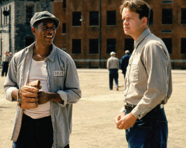 Main characters Andy Dufresne and Red standing together in the jail courtyard.