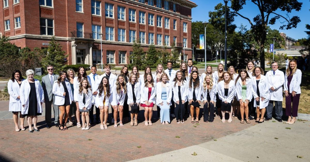 The inaugural class of bachelor of science in nursing (BSN) students pose with faculty for a picture following the University of Northern Iowa’s first ever white coat ceremony.